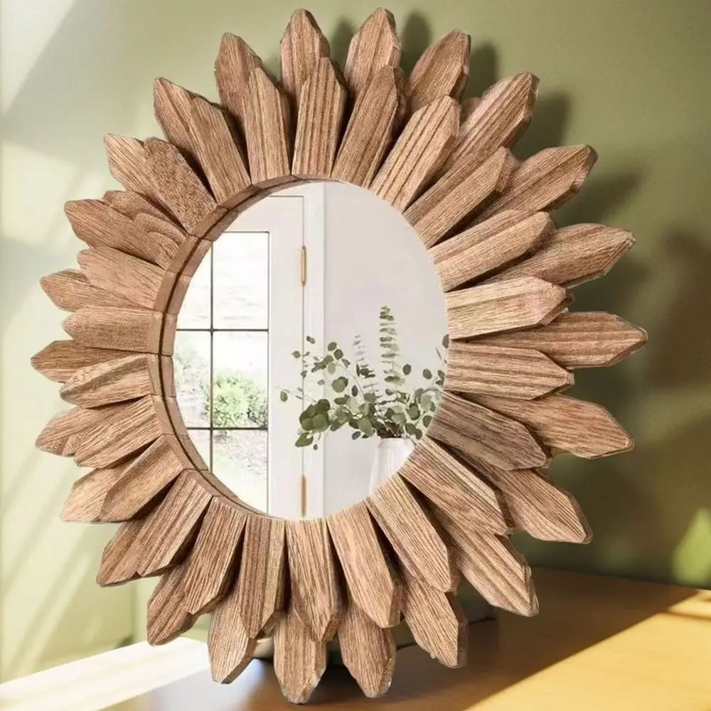 Round wooden sunflower wall mirror with layered petal design, displayed on a green accent wall in a bright, natural interior.